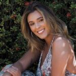 A woman with a joyful smile in a vibrant outdoor garden setting, perfect for lifestyle imagery.